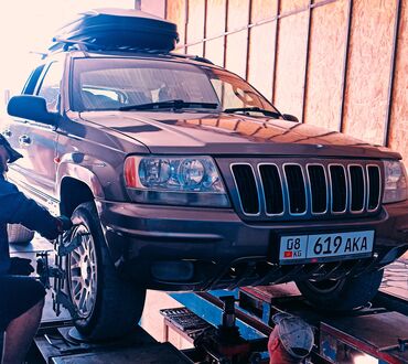 маленькая машина: Jeep Grand Cherokee, окрашенный в темно-серый цвет, представляет собой