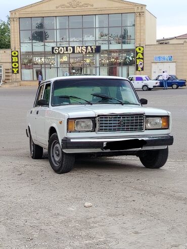 aqrar kend teserrufati texnika traktor satış bazari: Ağ rəngli dördqapılı sedan avtomobil. Ön tərəfində metal radiator