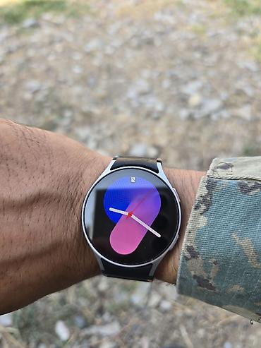 Ağıllı saat – dairəvi AMOLED ekranlı, incə metal korpuslu model. Qara
