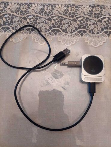 Gümüşü rəngdə, dairəvi düyməli Bluetooth qəbuledicisi. Qəbuledici USB
