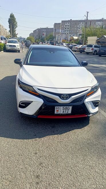 машине арзан: Белый седан Toyota Camry с черной крышей и красными акцентами на