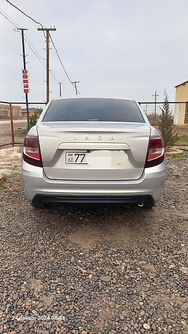 maşın şüşəsi: LADA Granta sedan, gümüşü rəngdə avtomobil. 4 qapılı kuzova malikdir — 3