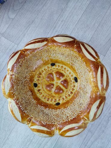 Выпечка, хлебобулочные изделия: Свежеиспеченный узбекский хлеб круглой формы, украшенный характерными — 5