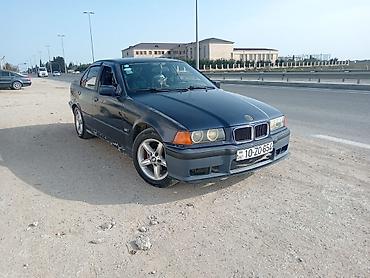 BMW: BMW E36 sedan kuzalı avtomobil. Tünd göy rəngdədir və klassik BMW — 1