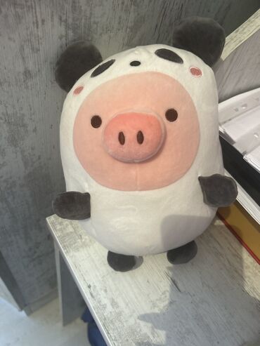 Ağ rəngli donuz formalı yumşaq oyuncaq. Bu yumşaq oyuncaq, panda