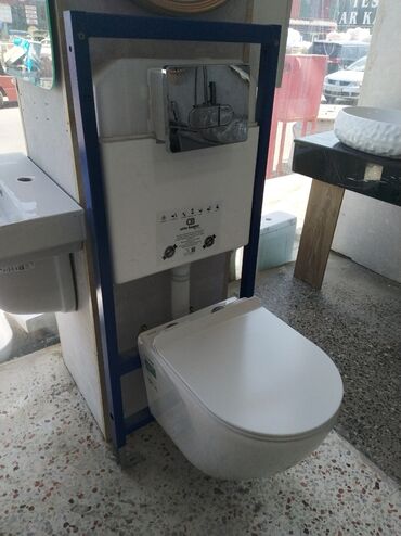 qosqu su ceni: Divara quraşdırılan unitaz dəsti, gizli su çəni və xrom düyməsi ilə