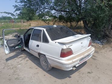 запчасти опель зафира а: Белый седан Daewoo Nexia, оснащенный спойлером на багажнике