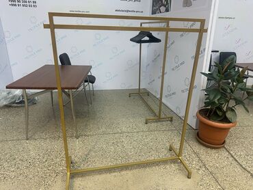 Mağaza asılqanları: Qızılı rəngdə, iki səviyyəli paltar asılqanı. Paltarları səliqəli