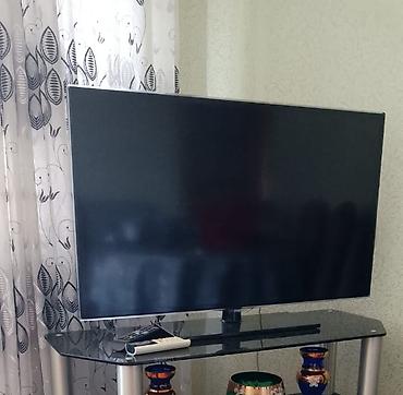 LED televizor, təxminən 43–50 düym ekran ölçüsü. Nazik çərçivəli, düz