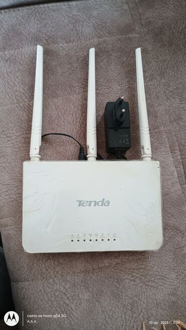 modemler: Tenda markalı, ağ rəngli, üç antenalı Wi-Fi router. Cihaz sabit və