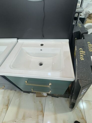 mətbəx moydadır: Ağ rəngli keramika lavabo və yaşıl rəngli iki siyirtməli şkafdan