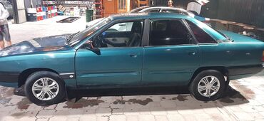 ретро авто: Седан Audi 100 C3 в изумрудном цвете, оснащенный четырьмя дверями