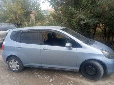 маленькая машина: Хэтчбек Honda Fit в светло-синем цвете, оснащенный четырьмя дверями