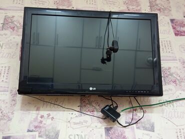 Divara quraşdırılmış qara rəngli LG LCD televizor. Televizorun altında