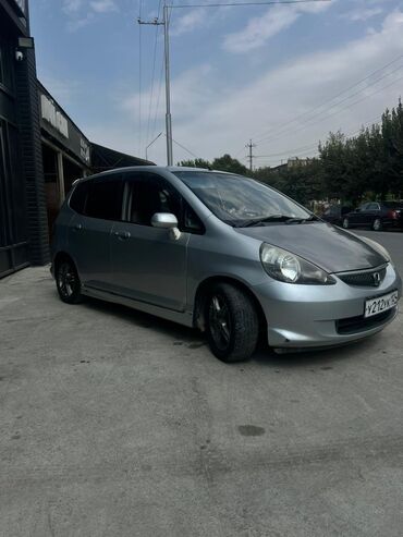 маленькая машина: Описание: Хэтчбек Honda Fit серебристого цвета, представленный на
