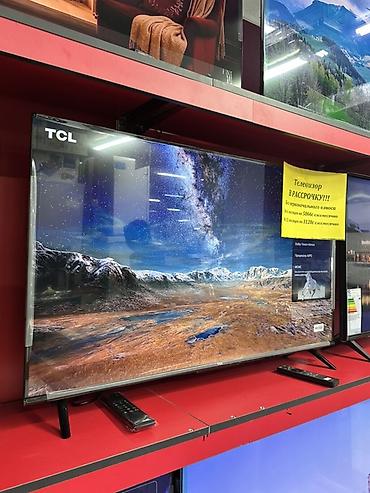 Телевизор TCL, диагональ примерно 55–65". Безрамочный дизайн с тонкими