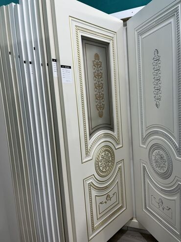 sendvic panel qiymeti: Ağ rəngdə olan, üzərində qızılı ornamentlər olan qapı. Qapının yuxarı