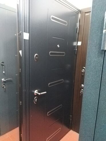 Kafel və bitirmə daşları: Qara rəngdə, metal konstruksiyalı giriş qapısı. Qapının üzərində