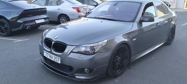 Boz rəngli BMW 5 Seriyalı sedan. Avtomobilin qabaq hissəsində qara