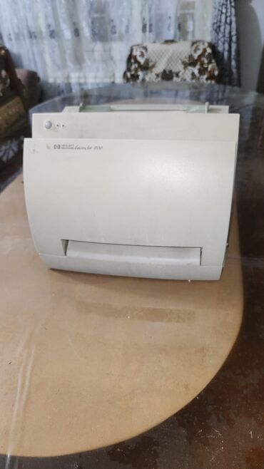 Masaüstü kompüterlər və iş stansiyaları: Ağ rəngdə, lazer texnologiyasına malik HP LaserJet 2100 printer. Cihaz
