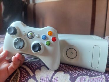 video çəkən: Ağ rəngdə "Xbox 360" konsolu. Model "Fat" gövdə tipinə malikdir. Disk