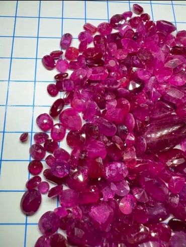 серебряный комплект с красными камнями: Коллекция ограненных рубинов различных форм, включая овальные, круглые