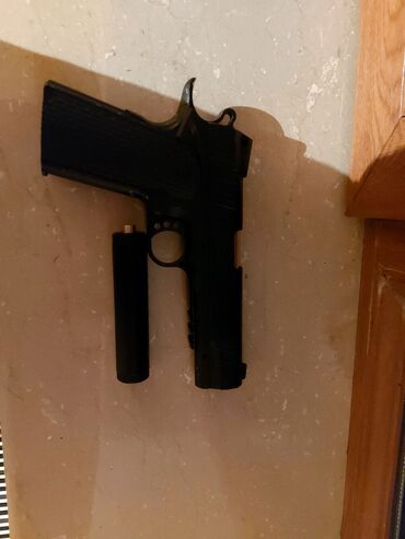 Uşağlar üçün oyuncaq tapanca satılır. susdurucu yanında verilir və