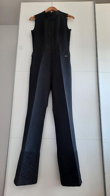 Elegantni crni ženski kombinezon bez rukava NACO, br.38 - Klasičan na lalafo.rs Elegantni crni ženski kombinezon bez rukava NACO, br.38 - Klasičan