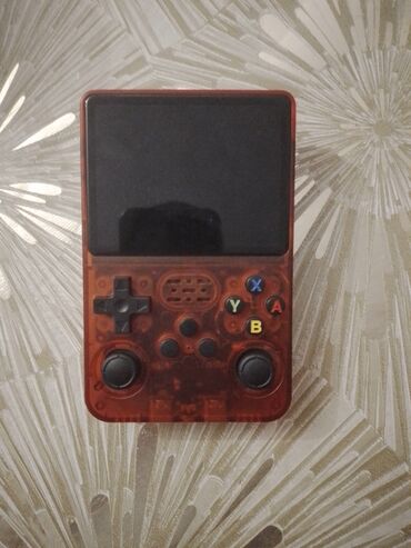 playstation portable купить: Şəffaf qırmızı korpuslu, yığcam portativ oyun konsolu yolda və ya evdə