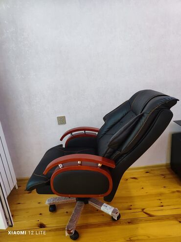 Ofis dolabları: Ofis kreslosu qara dəri üzlüklərlə və qırmızı ağacdan hazırlanmış