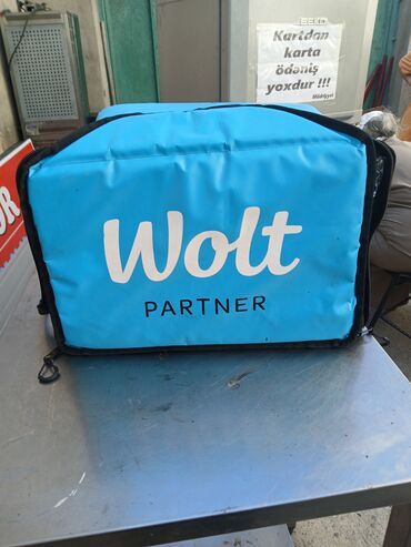 zibil qutularının rəngləri: Wolt Partner markalı, göy rəngli çatdırılma çantası. Yeməkləri təzə və