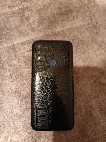 Arxa tərəfində timsah dərisi naxışlı, qara rəngdə smartfon. Cihazın