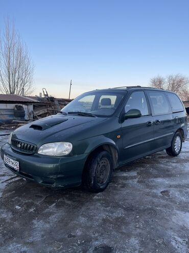 шыны r14: Минивэн Kia Carnival зеленого цвета, оснащенный багажником на крыше