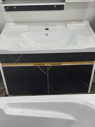 Çanaq üçün kranlar: Ağ keramika lavabo və qara rəngli ikiqapılı şkafdan ibarət hamam