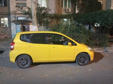 мини электромобиль: Яркий желтый хэтчбек Honda Fit с пятидверным кузовом, выполненный в
