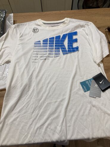 Ağ rəngli, qısaqol Nike t-shirt. Köynəyin ön hissəsində mavi rəngdə