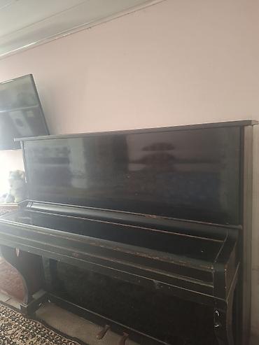 piano az: Qara rəngli, klassik üslubda akustik pianino. Korpus üzərində — 5