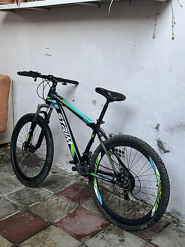boyuk velosiped: Qara rəngli, yaşıl və mavi vurğulara malik dağ velosipedi. Velosipeddə — 3
