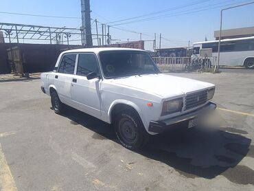 Ağ rəngli Lada 2107 sedan avtomobili. Avtomobilin dörd qapısı və geniş