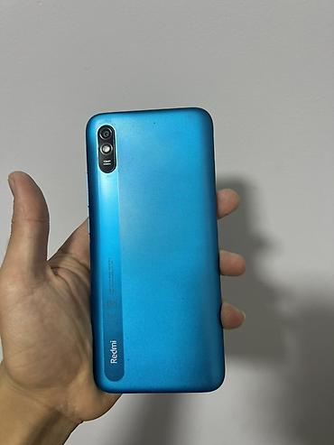 Смартфон Redmi (серия A/9A уровня) в голубом цвете. Особенности: -