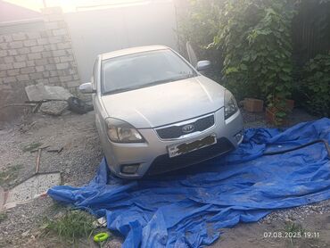 Gümüşü rəngli Kia Pride (Rio) sedan avtomobili. Avtomobilin arxa