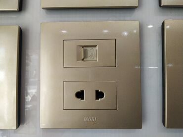 xar tut: Qızılı rəngdə, divara quraşdırılan elektrik rozetkası və telefon