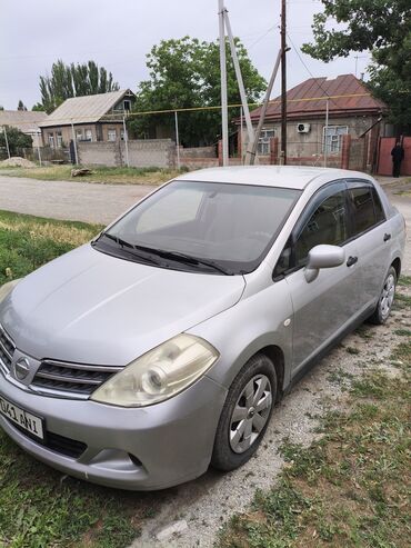 купить авто ваз 21099: Серебристый седан Nissan Tiida с четырьмя дверями, идеально подходящий