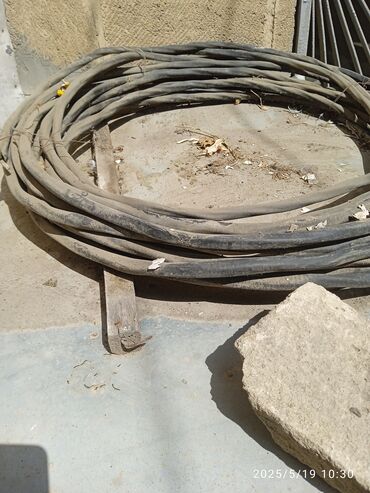 Qara rəngdə, sarğılı elektrik kabeli. Evdə və ya sənayedə elektrik