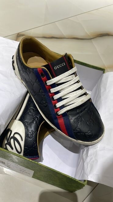 krasofkalar kisi: Qara rəngli, üzərində Gucci loqosu olan dəri kişi idman ayaqqabıları