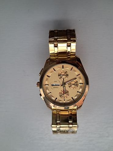 is geyimi: Qızılı rəngli qol saatı - Brend: Tissot (korpus arxasında “TISSOT — 1