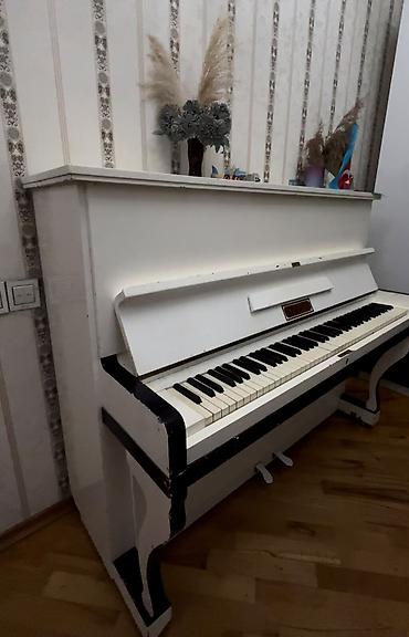 Upright (dik) pianino – klassik ağ rəngdə, qara detallarla. - Tam
