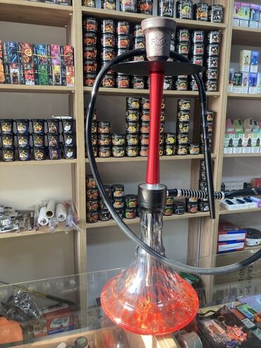 traktor altlıqlı qara qadın bosonojkaları: Şəffaf şüşə əsaslı və qırmızı metal gövdəli qəlyan. Qəlyanın yuxarı