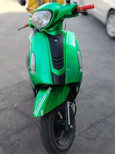 Yaşıl rəngli moped, şəhər daxili səyahətlər və çatdırılma üçün