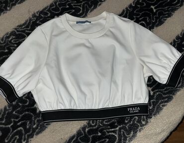 Пиджаки: Ağ rəngli, qısaqol Prada top. Topun qolları qara rəngdədir və elastik